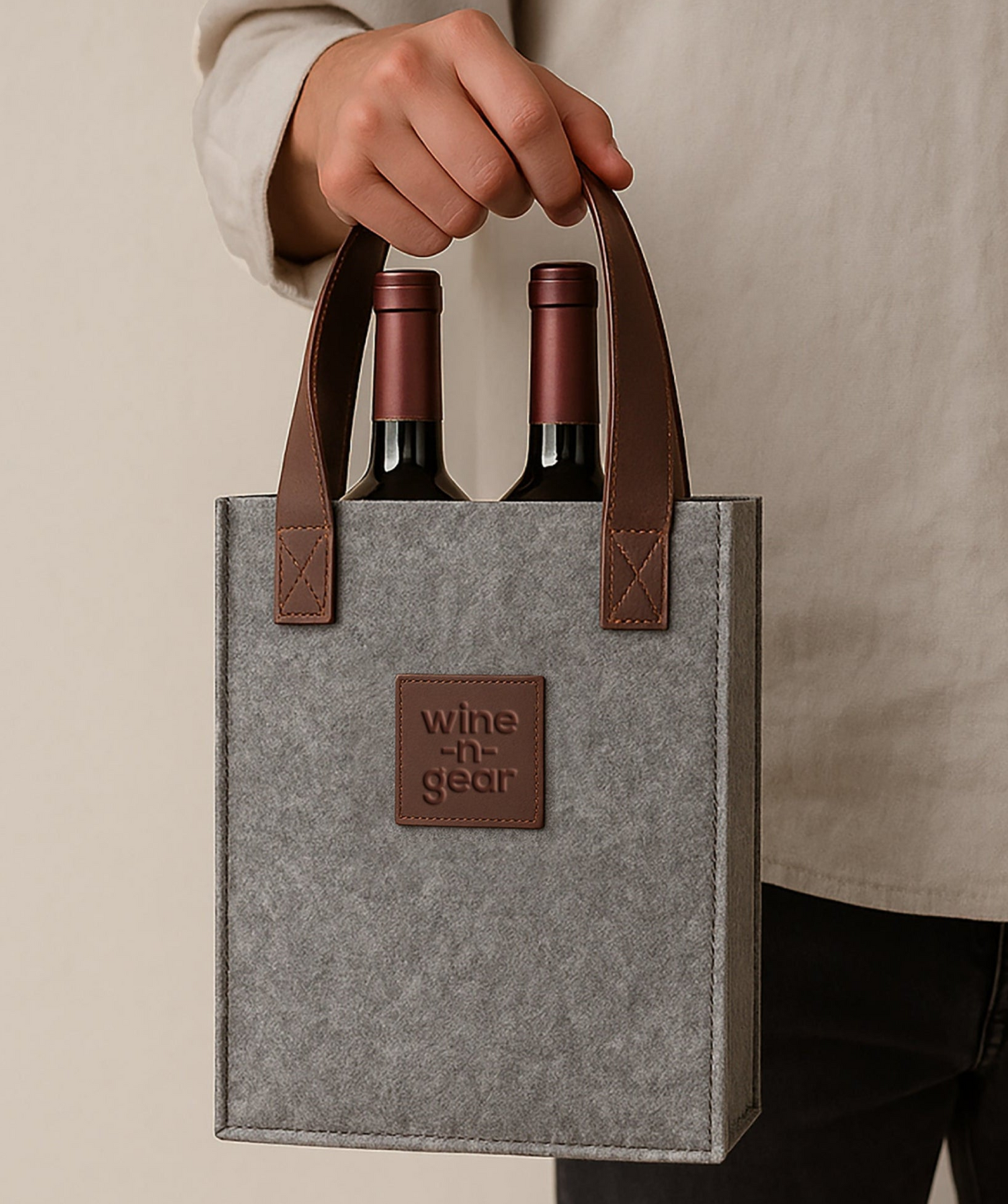 Gray wine bag with brown handles holding two bottles of wine, branded 'wine-n-gear'.